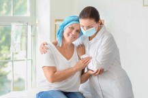 Doctor comforting mature woman after chemotherapy in clinic